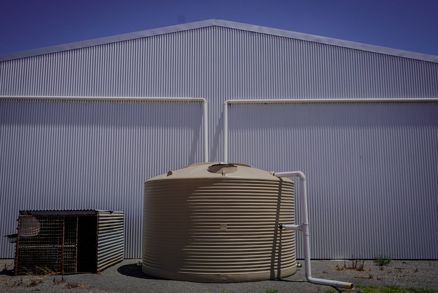 22,500ltr Round Poly Water Tank in Beige Colour installed by a shed