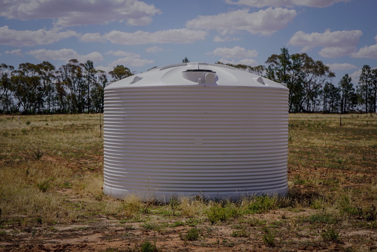 22,500ltr Round Poly Water Tank in White Colour sitting in a field