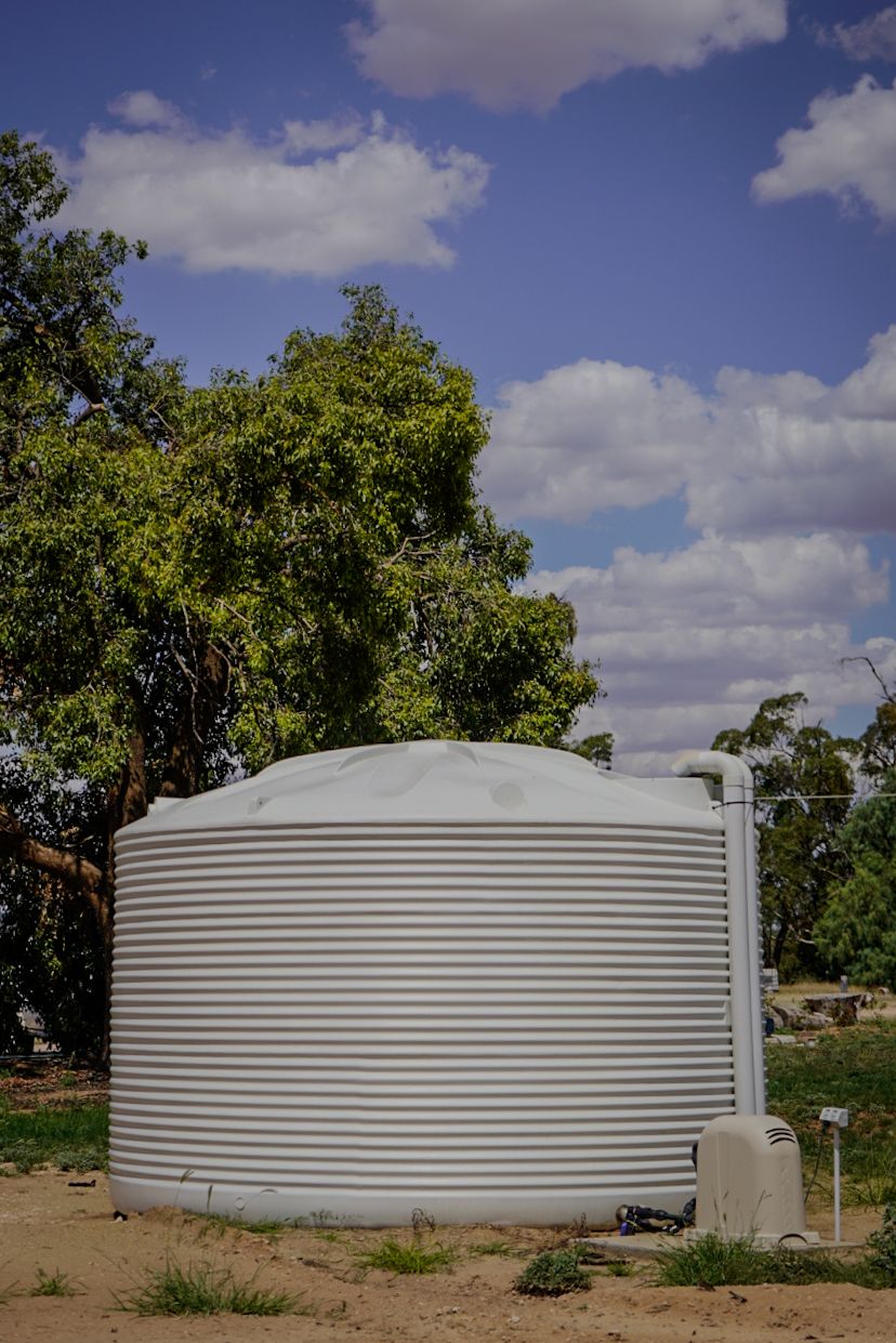 22,500ltr Round Poly Water Tank in White installed with a Pump
